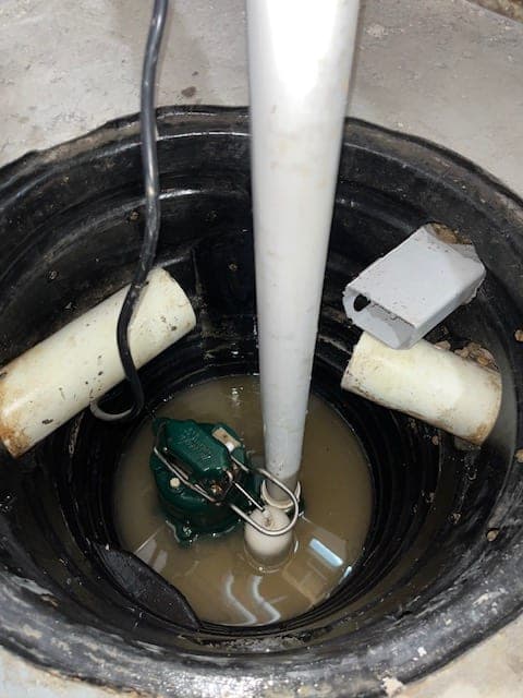 Sump pit with muddy standing water before service