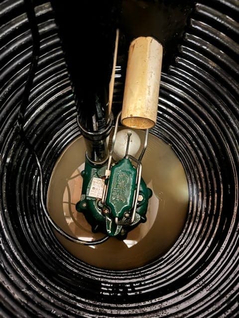 Close-up of a Zoeller pump with a ball-float switch inside a sump basin