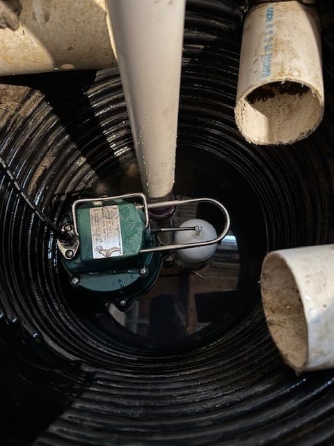 Zoeller sump pump installed in a corrugated basin with clean PVC discharge lines